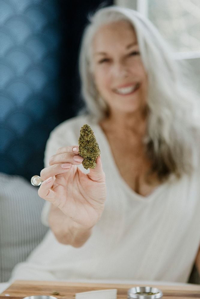 Senior woman holding a green weed