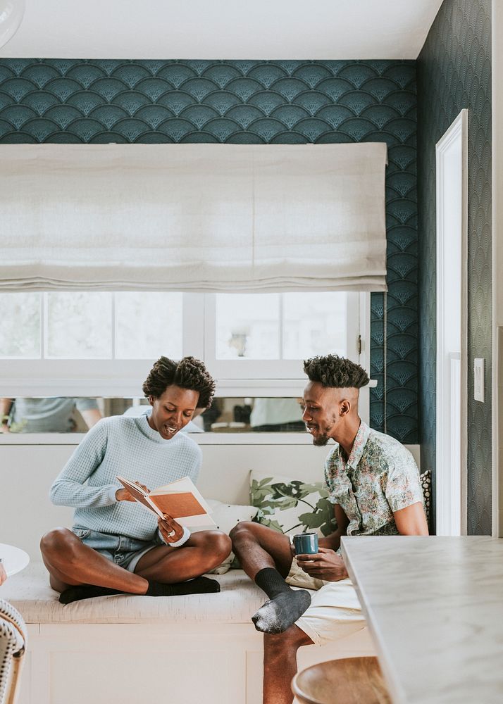 Happy black couple reading a book at home