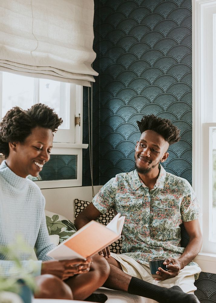 Happy black couple reading a book at home