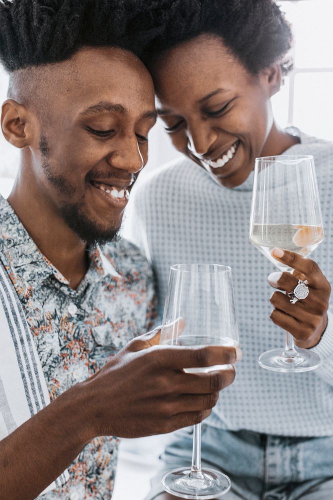 Happy couple enjoying a glass of wine in the kitchen