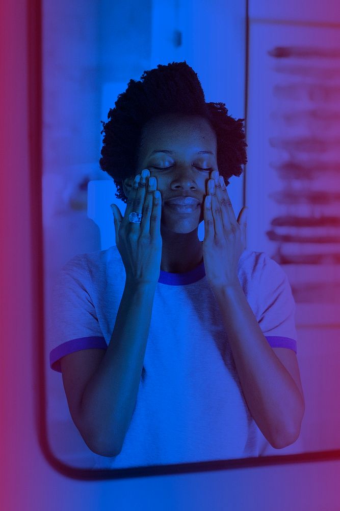 African woman standing by the mirror in the bathroom