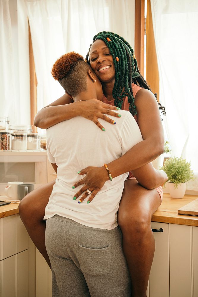 Happy gay couple hugging in the kitchen