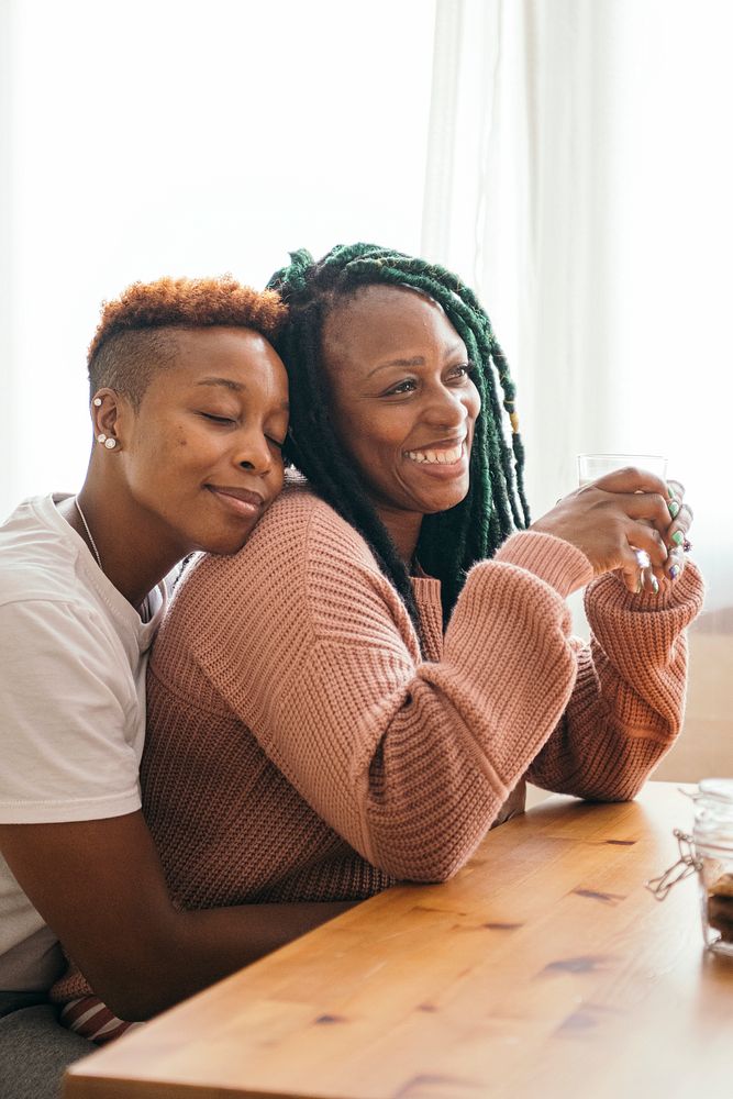 Romantic lesbian couple cuddling at the table