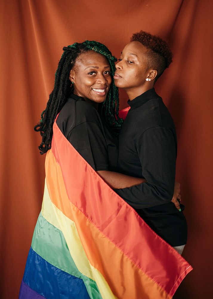 Happy lesbian couple with a colorful flag