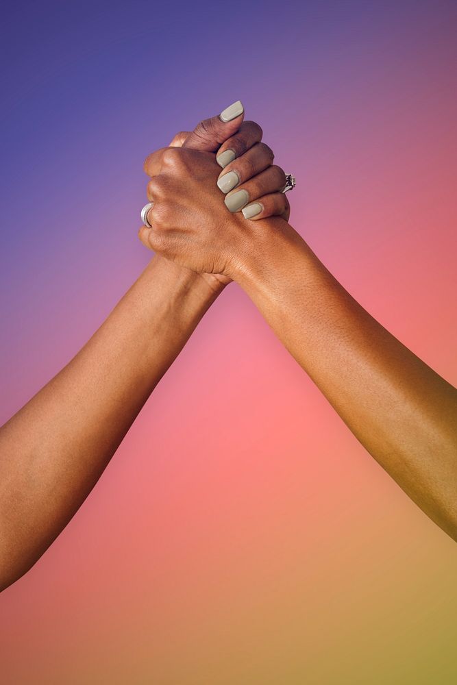 Gay couple holding hands on a colorful rainbow gradient background