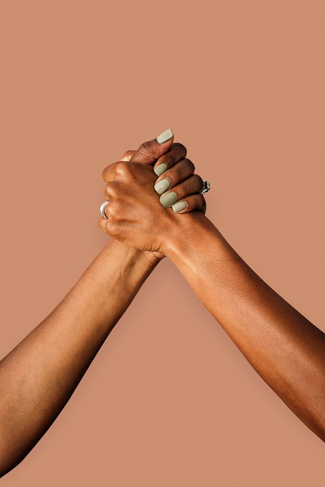 Couple holding hands on a peach background