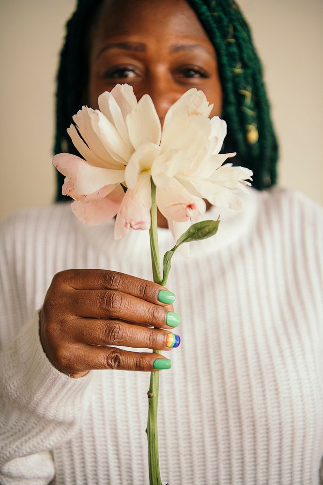 Happy black woman holding a white flower
