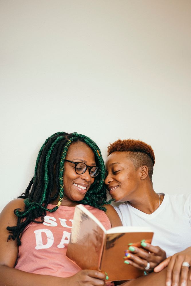 Happy lesbian couple reading a book together