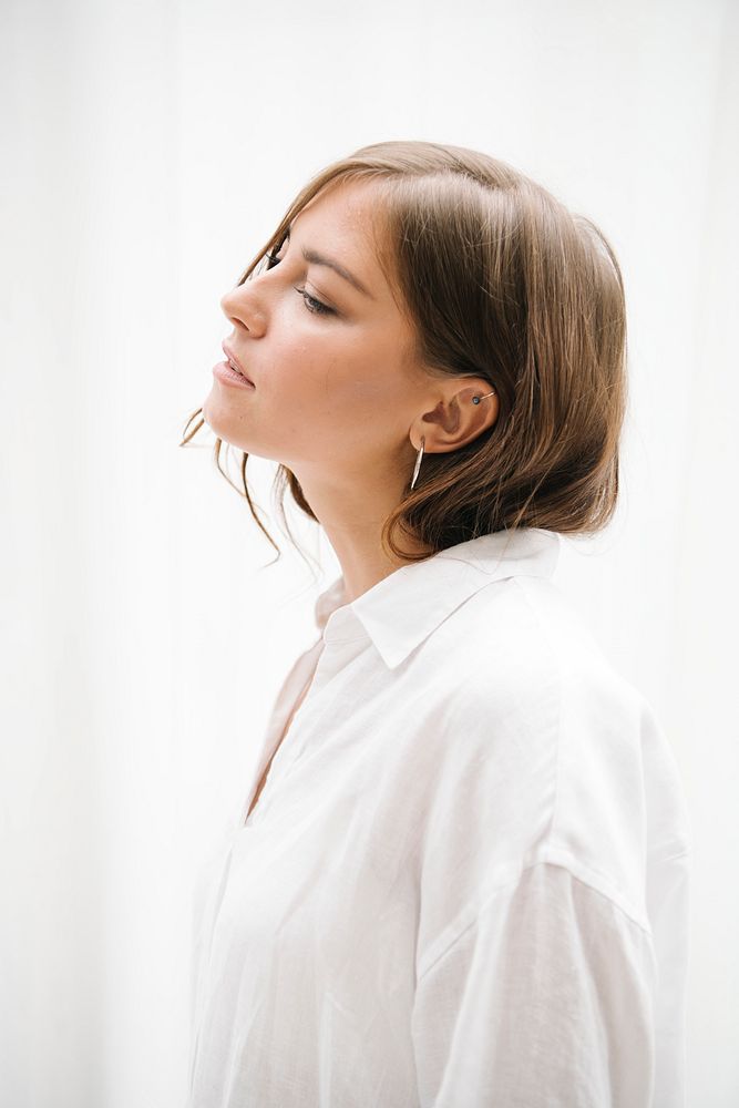Side view of a brown hair woman in a white shirt