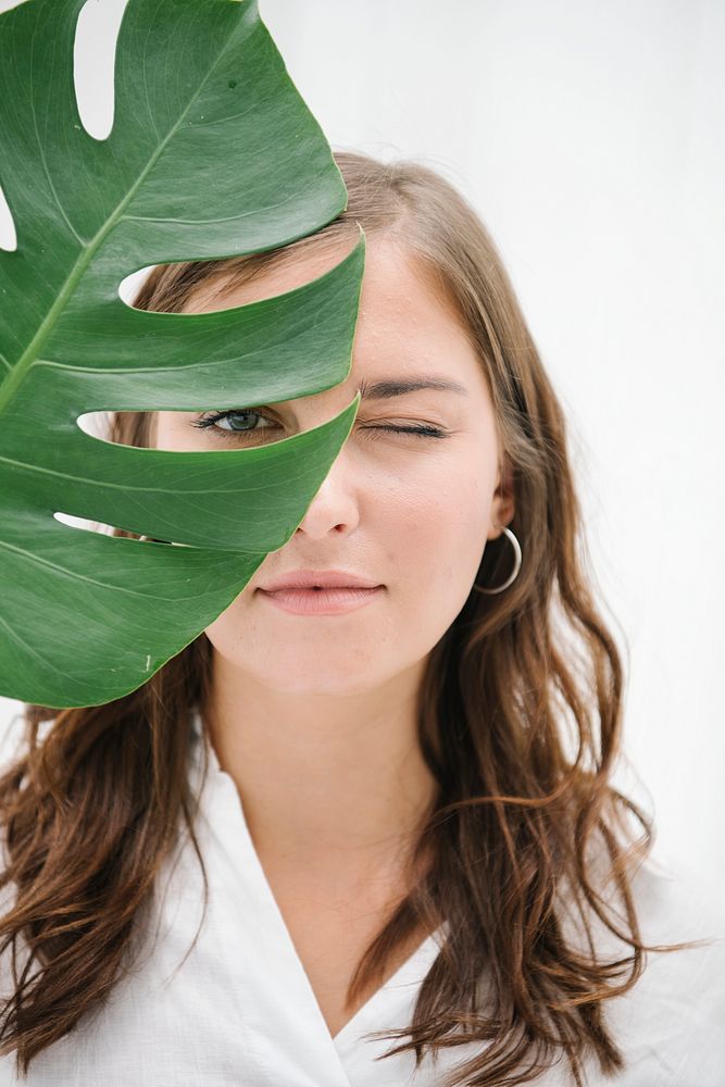 Portrait of a woman with monstera leaf