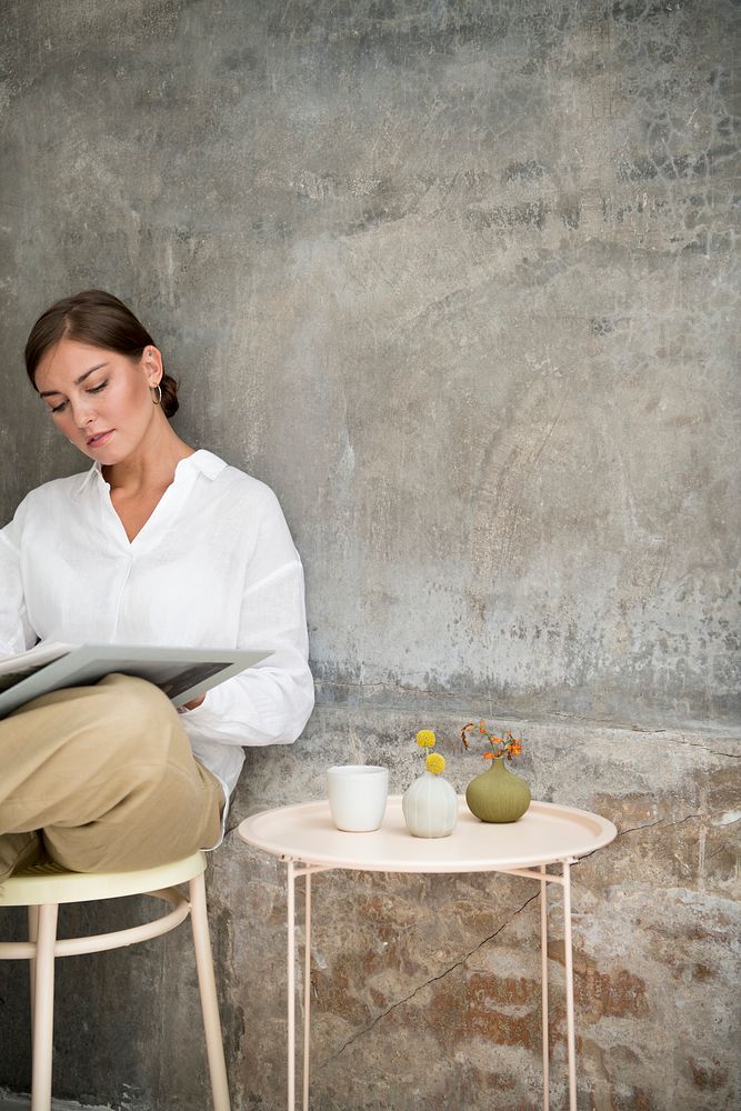 Woman sitting on a stool and reading a book