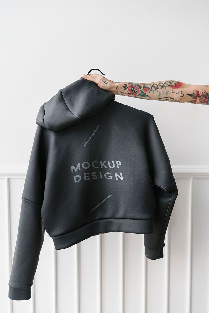 Tattooed woman holding a gray hoodie mockup