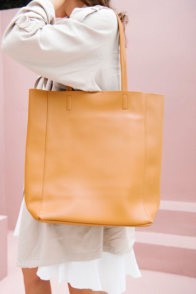 Woman in a beige coat with her brown tote bag