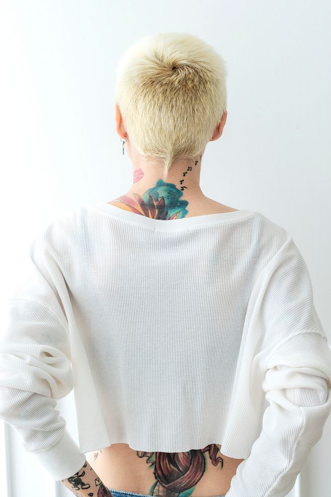 Tattooed woman with hands tucked in her jeans back pocket