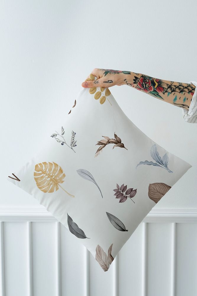 Tattooed woman holding a leafy pillow mockup