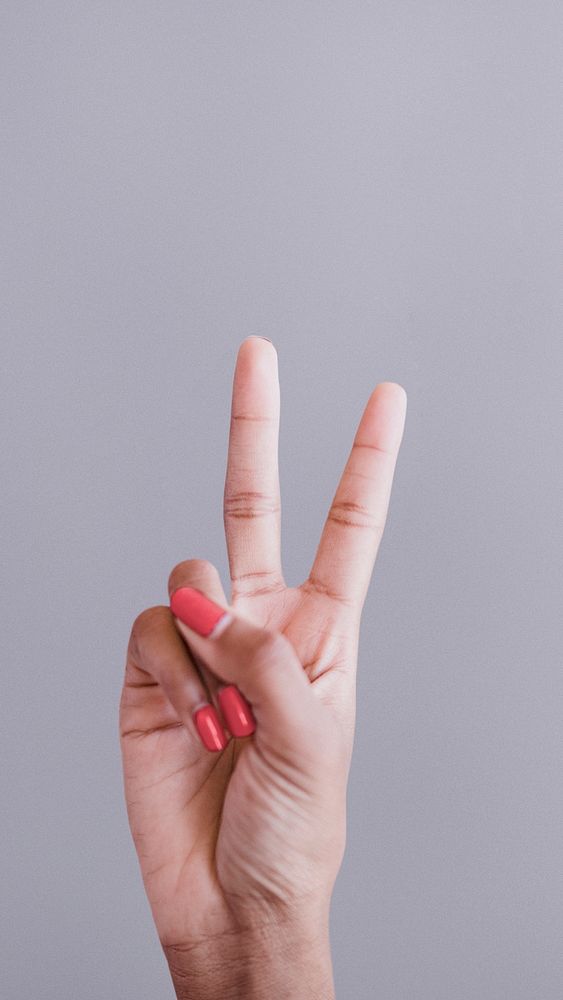 Woman showing a peace hand sign mobile phone wallpaper