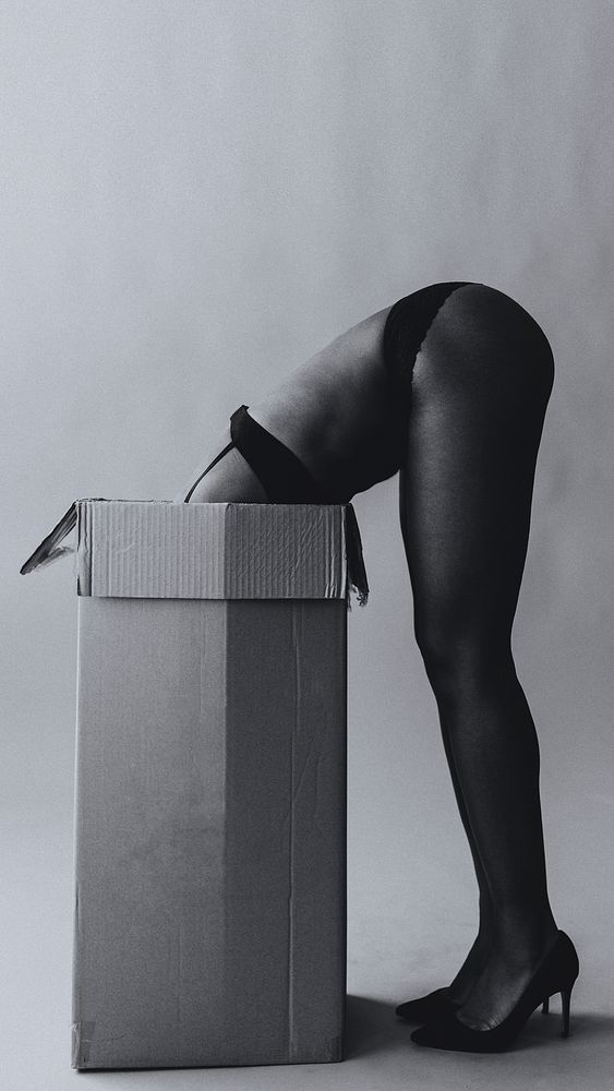 Naked black woman with her head in a cardboard box