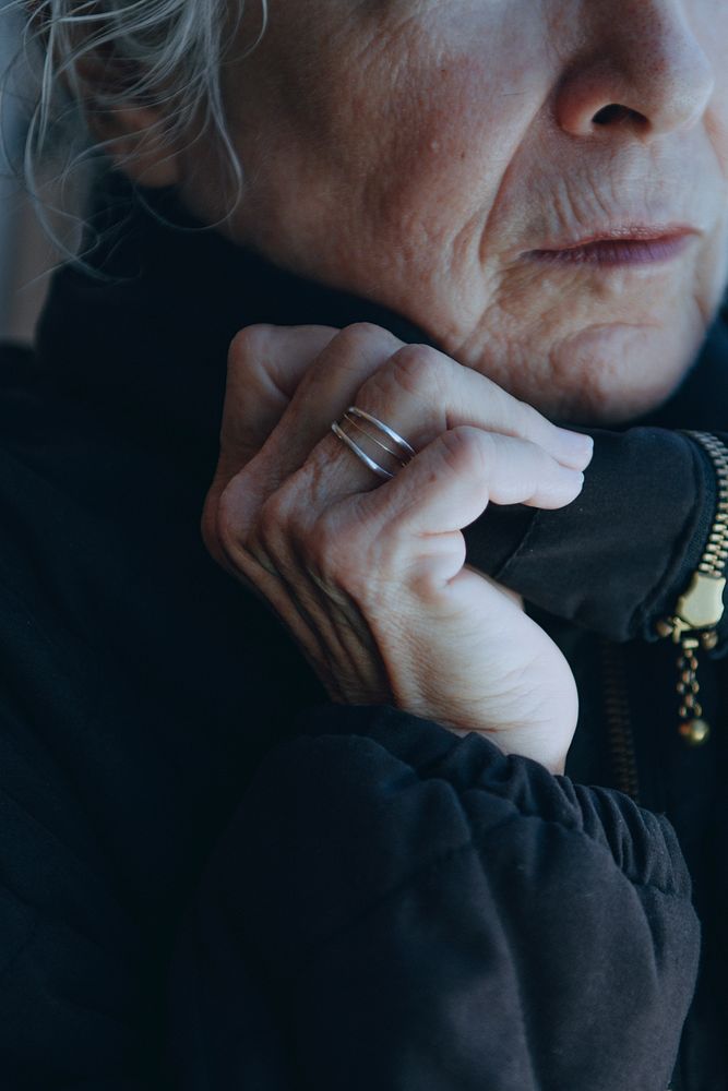 Old woman warming up herself in a cold winter day