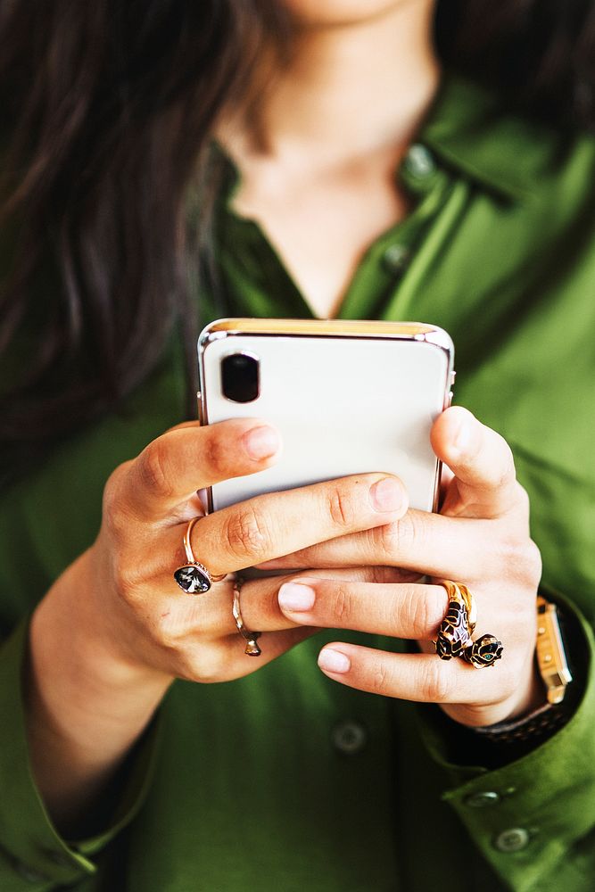 Woman in silk green shirt using a smartphone