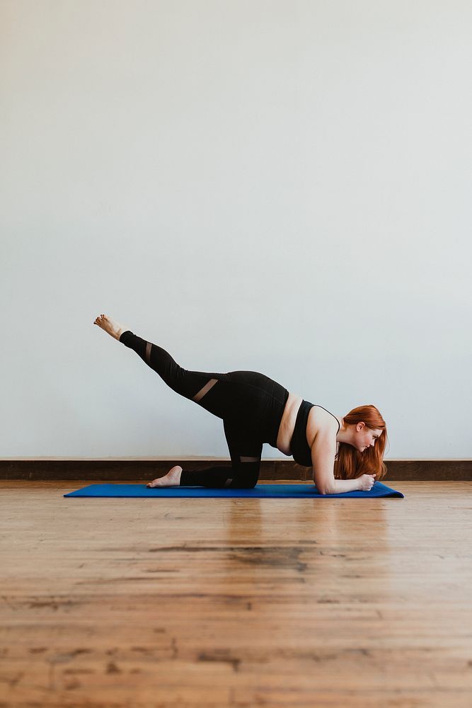 Sporty woman stretching her legs on a yoga mat