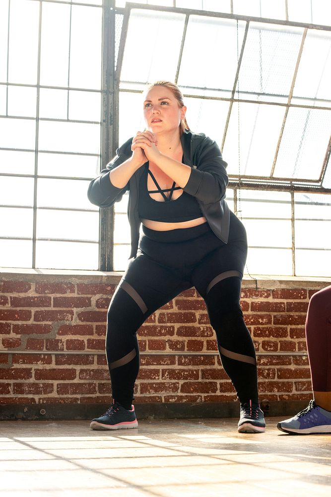 Woman doing squats in fitness class