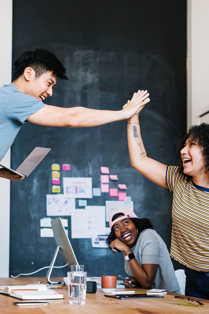 Happy diverse colleagues in a startup company doing a high five