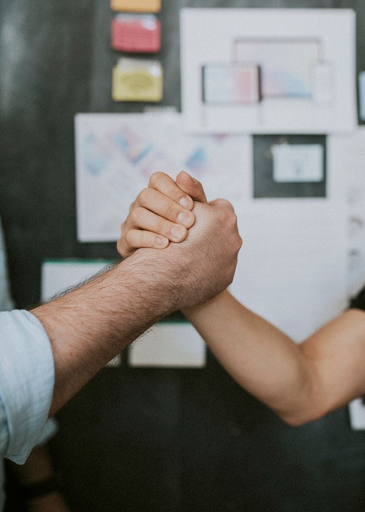 Colleagues holding hands in the office