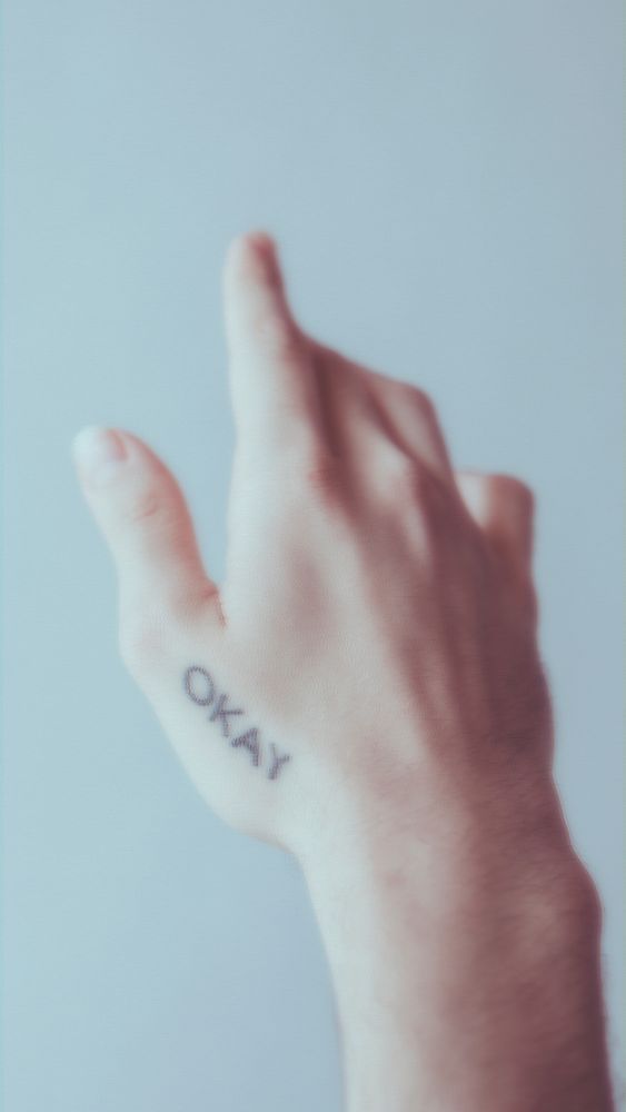 Okay word tattooed on a hand mobile phone wallpaper