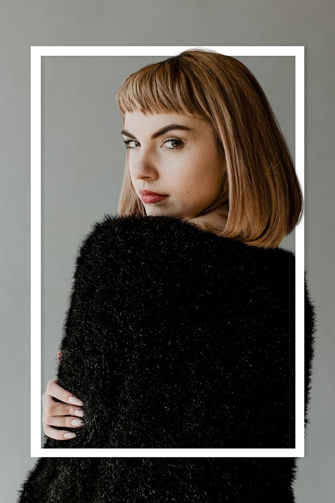 Brown hair woman in a black fluffy sweater looking back over her shoulder