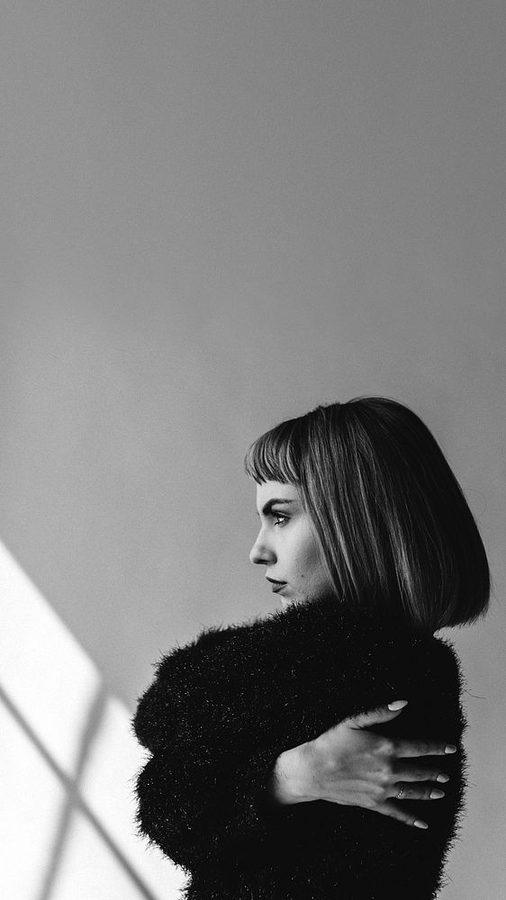 Short hair woman in a black fluffy sweater hugging herself