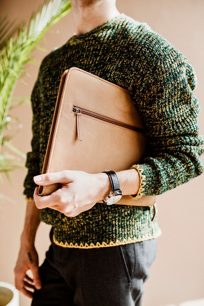 Man in a green sweater carrying a laptop bag