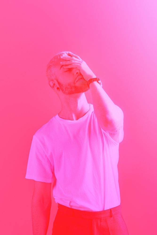 Depressed man covering his face pink filter effect
