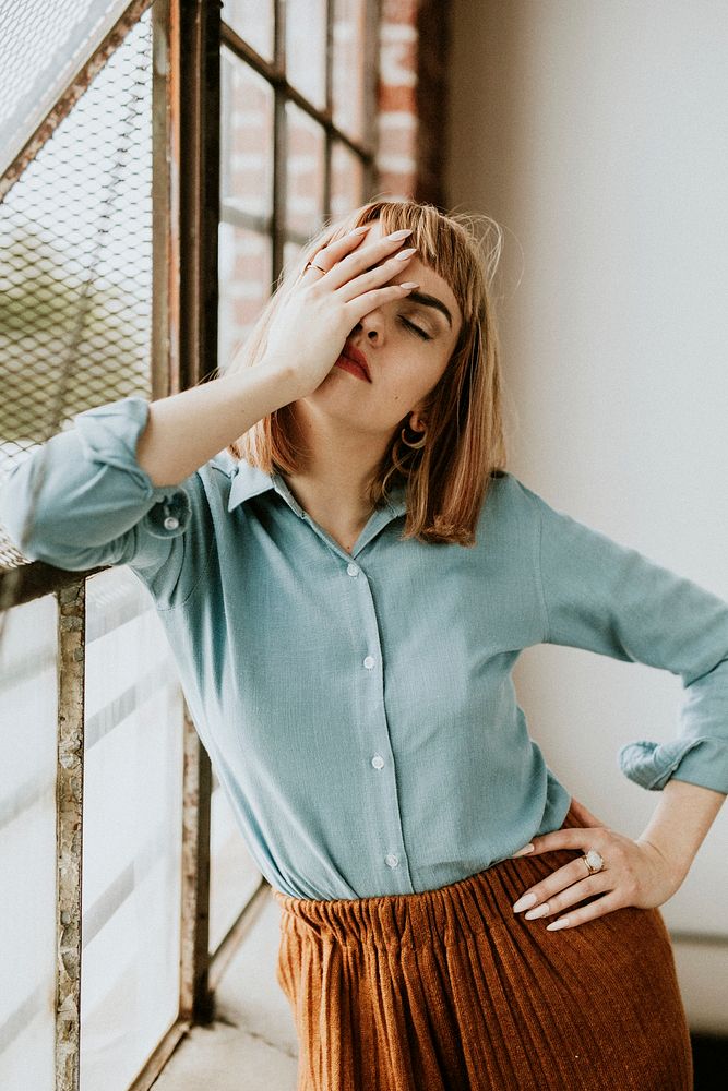 Woman in a blue shirt by the window