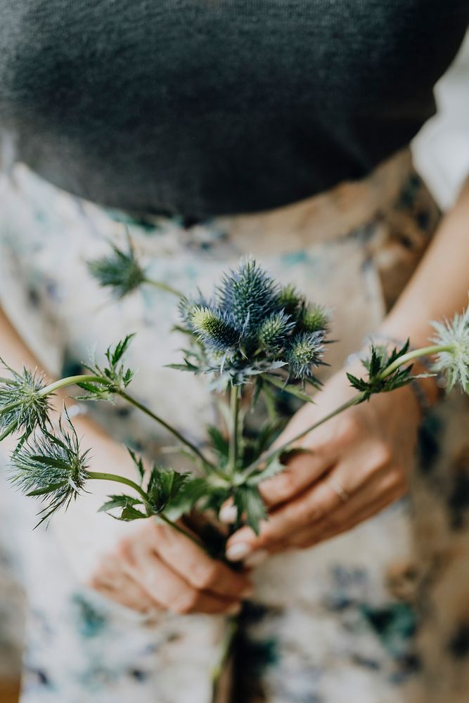 Woman holding a blue thistle