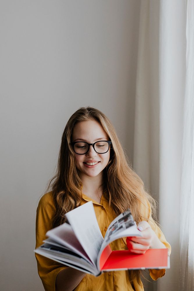 Cheerful blond girl opening a book