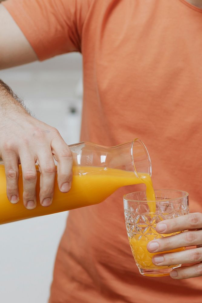 Man pouring orange juice into a glass