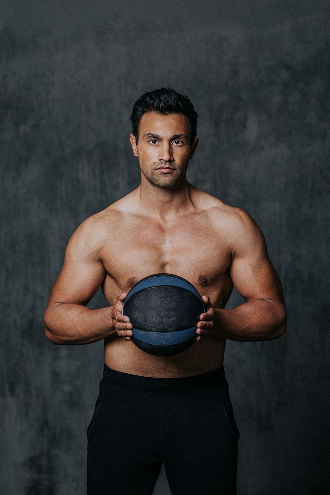 Shirtless muscular man holding a fitness ball