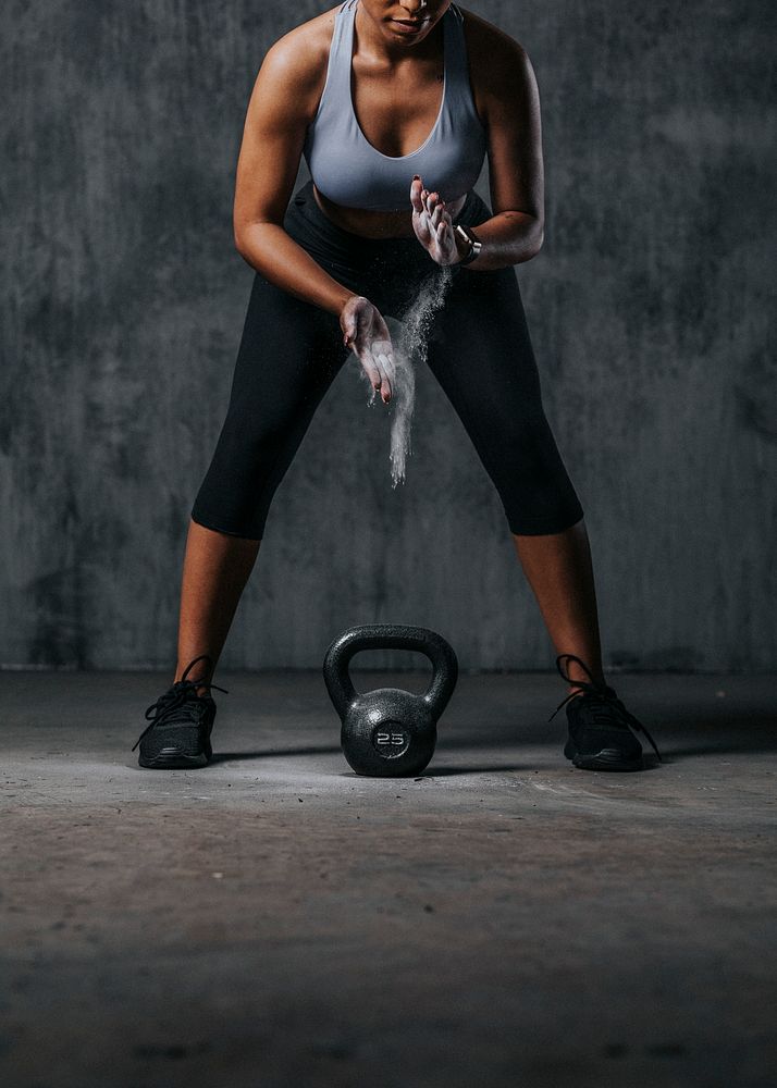 Sportive woman getting ready to lift a kettlebell