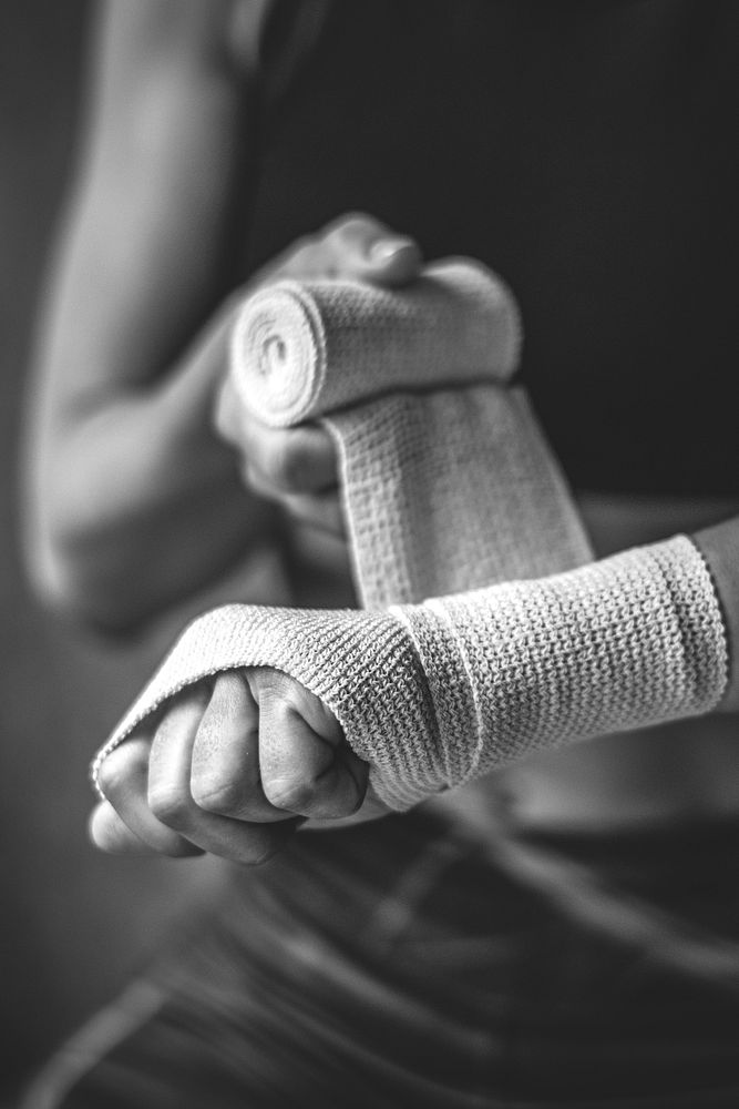 Female boxer putting a strap on her hand