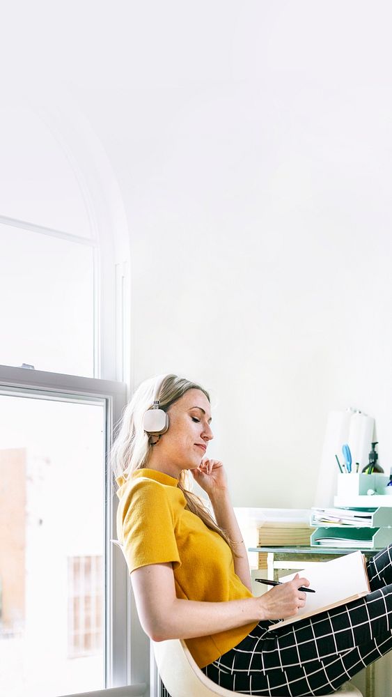 Casual woman in an office with headphones