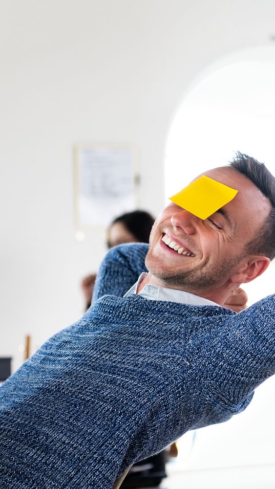 A happy businessman with blank sticky note on his forehead