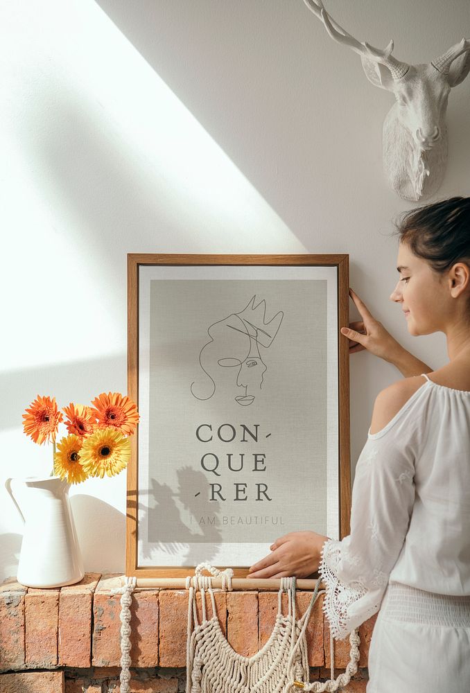 Girl decorating a wall with a conqueror frame