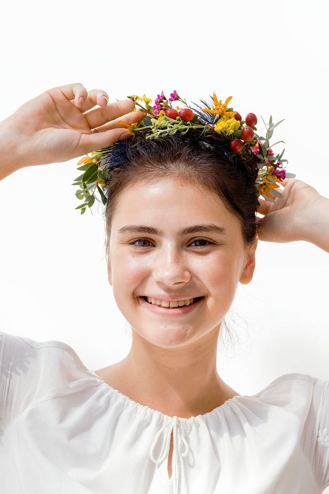 Beautiful young woman with a midsummer floral wreath