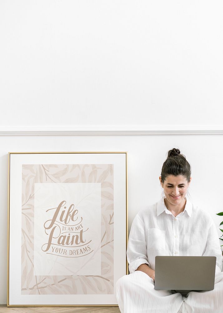 Woman with a laptop sitting by a frame mockup