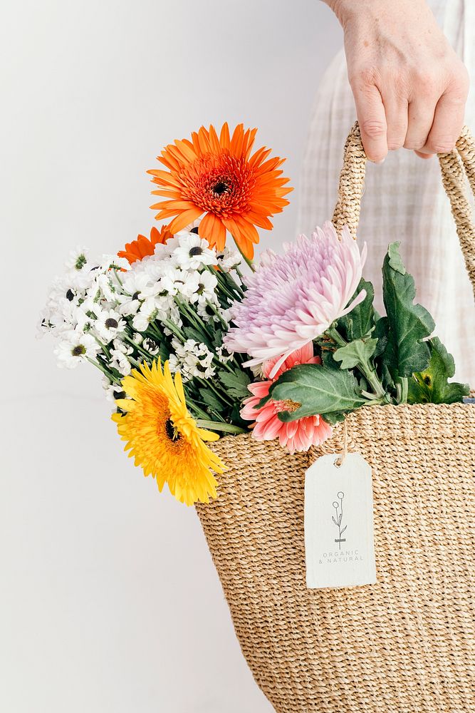 Colorful tropical flowers in a woven bag with a card mockup