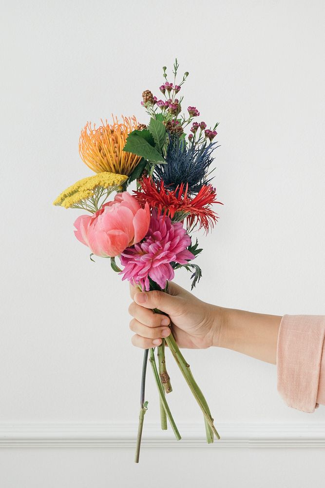 Woman holding up a tropical flower bouquet