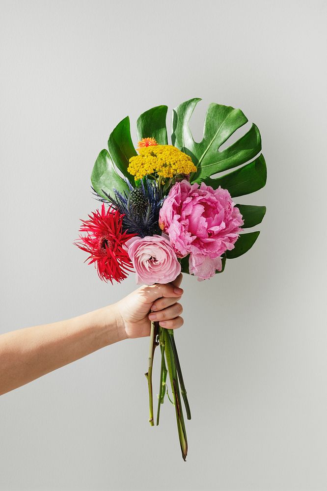 Woman holding up a tropical flower bouquet