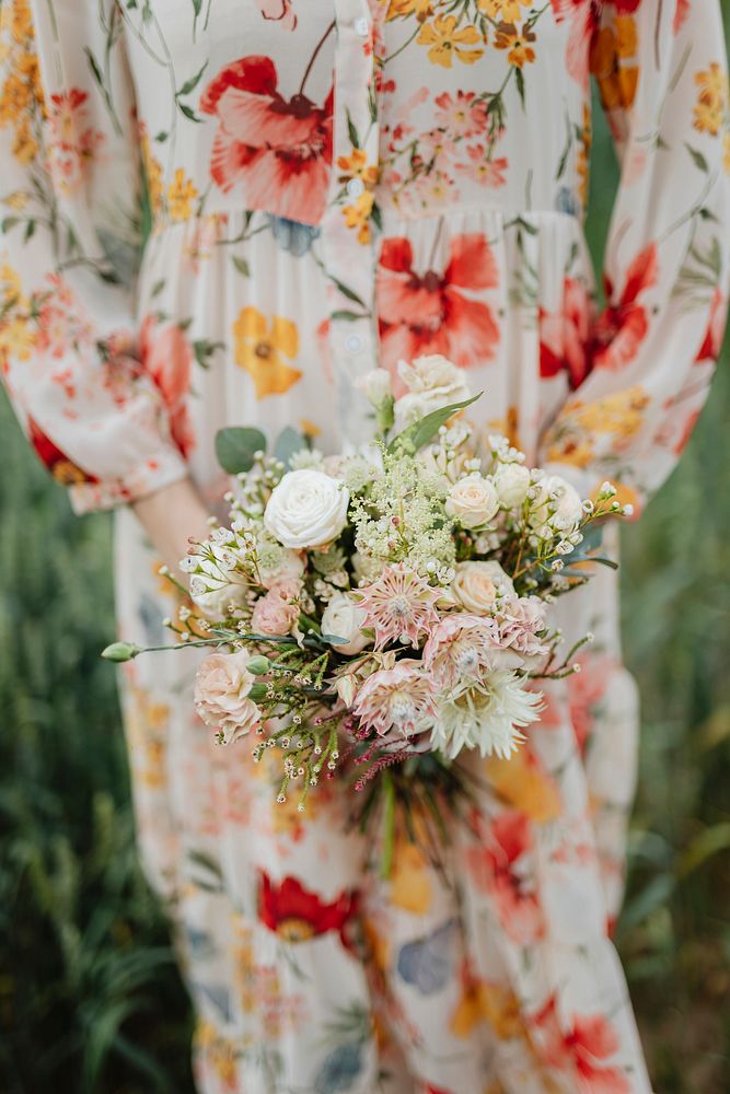 Woman in a floral dress holding a flower bouquet