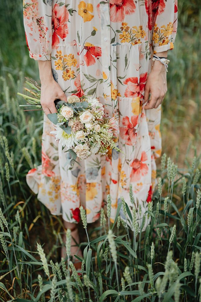 Woman in a floral dress holding a flower bouquet