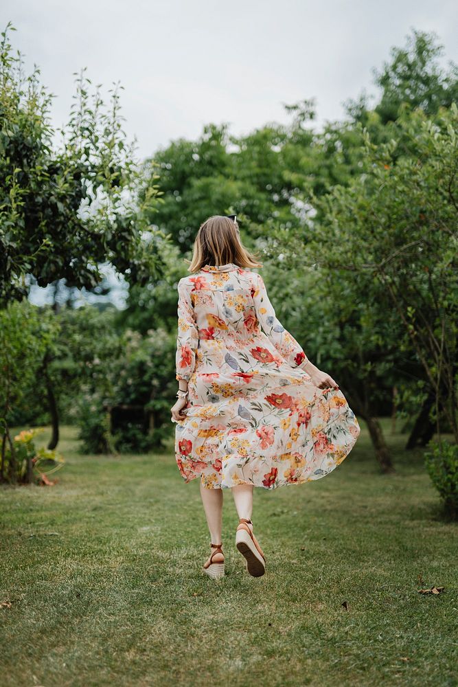 Woman in a floral dress walking in a garden